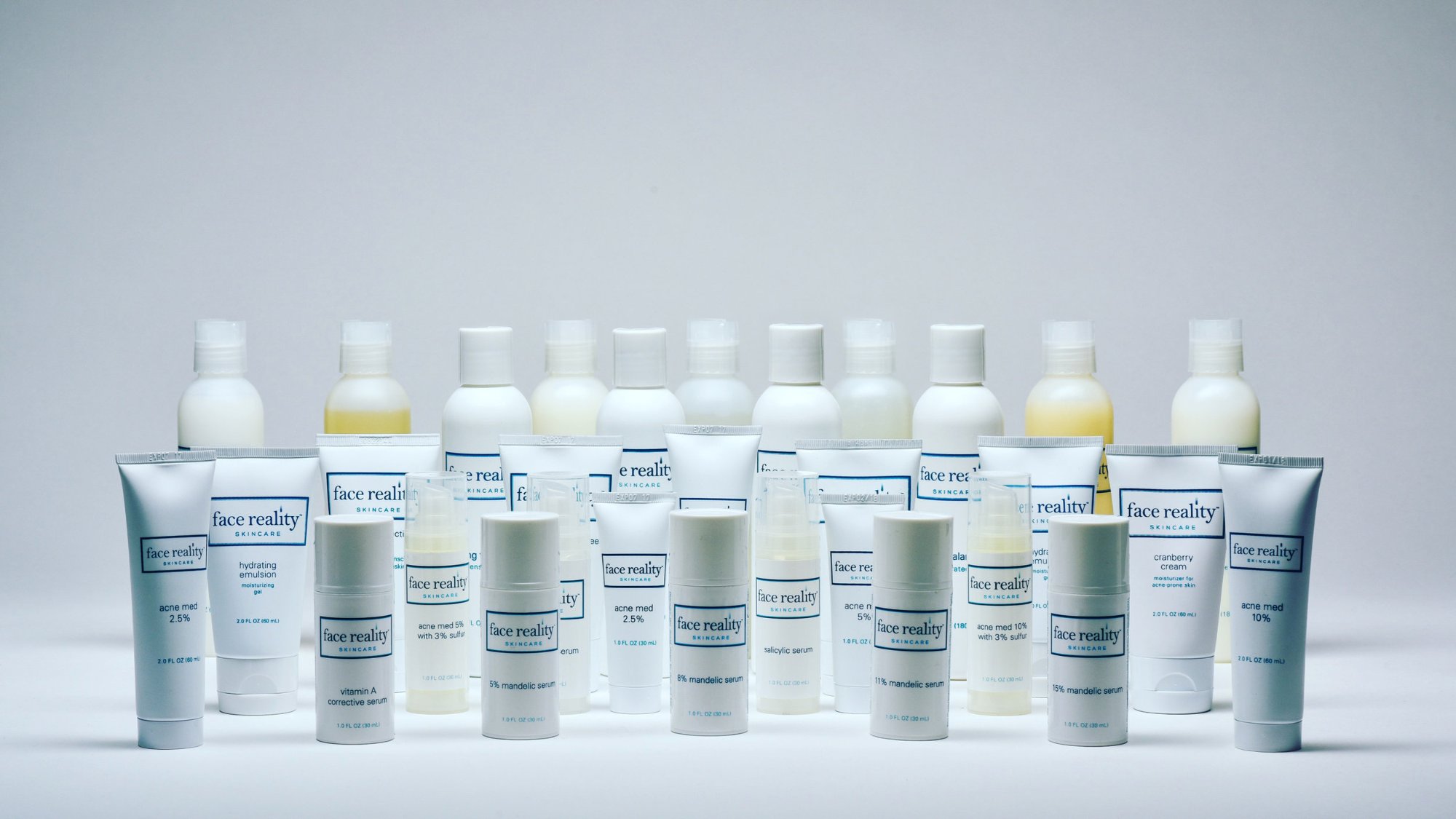 A row of Face Reality Skincare cleansers, toners, serums and moisturizers